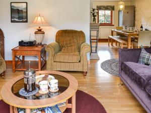 a living room with a couch and a table at Oakwood Cottage - Glencoe in Glencoe