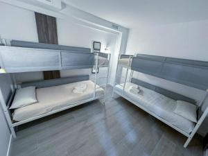 two bunk beds in a room with wooden floors at Boliches 71 Hostel in Fuengirola