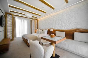 a bedroom with a bed and a couch and a table at Escapes Boutique Hotel & Restaurant in Dilijan