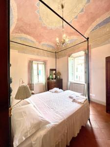 a bedroom with a large white bed with a ceiling at The house of Cetona in piazza Paré in Cetona