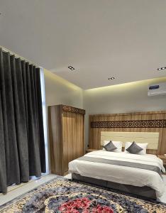 a bedroom with a large bed and a large window at شقق المطار in Jeddah