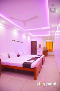 a room with two beds and a ceiling at Stay Point Calicut Beach in Kozhikode