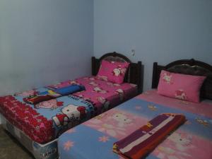 two beds sitting next to each other in a bedroom at Sawe Homestay in Kuta Lombok