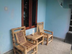 two wicker chairs and a table in a room at Sawe Homestay in Kuta Lombok
