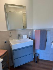 a bathroom with a sink and a mirror and towels at Ferienwohnung Pommerbachquelle in Kaisersesch