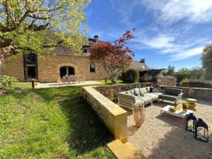 un cortile con un divano e un muro di pietra di La longère de Sarlat a Sarlat-la-Canéda