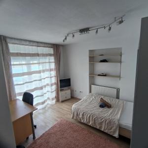 a bedroom with a bed and a desk and a window at Bahnhofs-und Zentrumsnahe schöne 2-Zimmer Wohnung in Landshut