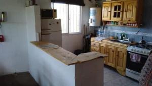 eine Küche mit Holzschränken und einer Arbeitsplatte in der Unterkunft Rincón Peralta Córdoba in Valle Hermoso