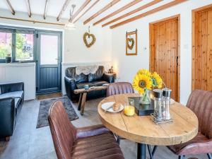 ein Wohnzimmer mit einem Holztisch und Stühlen in der Unterkunft The Old Cowsheds 5 - Llanilar - Uk49790 in Cribyn