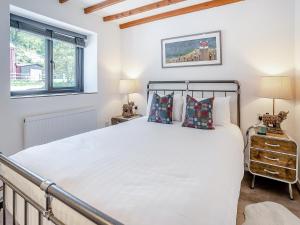 ein Schlafzimmer mit einem großen Bett und zwei Fenstern in der Unterkunft The Old Cowsheds 5 - Llanilar - Uk49790 in Cribyn