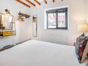 ein Schlafzimmer mit einem Bett und einem Fenster in der Unterkunft The Old Cowsheds 5 - Llanilar - Uk49790 in Cribyn + 9 Fotos