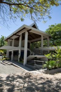 a large white building with a roof at Karancho Beach House in Mactan