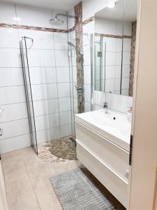 a bathroom with a sink and a shower at Appartment Wie Heim in Überherrn +4 photos