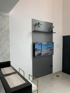 a room with a wall with a picture of a beach at Loft de luxo em Peruíbe, 3 minutos da praia in Peruíbe