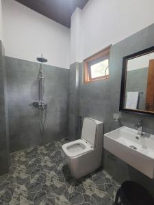 un baño con inodoro y lavabo en Charisma Apartments, en Ahangama 33 fotos más