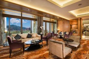 a living room filled with furniture and a large window at Hotel Okura Macau in Macau