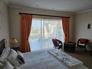 a bedroom with a bed and a large window at Somerset Hill in Somerset West