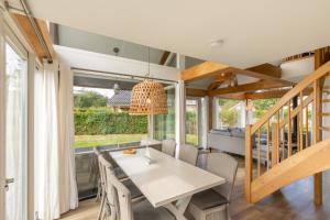 a dining room with a table and chairs at Welcome in - Zonnedorp Kavel 10 Renesse | Villa nabij het Strand & met Ruime Tuin in Renesse