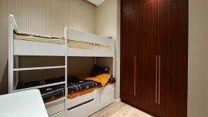 a small room with a bunk bed and a closet at Nest One Luxury Apt View of the Entire City from the Top in Tashkent