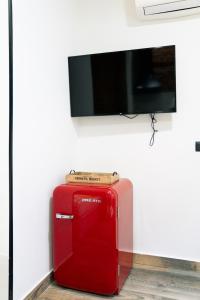 a red suitcase sitting under a flat screen tv at Bernabéu Business & Stay in Madrid