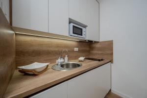 a kitchen counter with a sink and a microwave at Apartman White Pearl in Palić