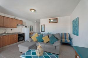 a living room with a couch and a kitchen at Las Floritas in Playa de las Americas