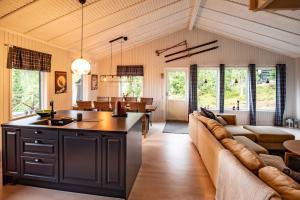 a kitchen and living room with a couch and a table at Trysilfjellet Nord 267 in Trysil