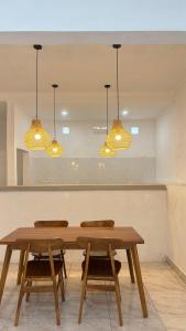 ein Esszimmer mit zwei Tischen und zwei Leuchten in der Unterkunft pondokasih in Uluwatu