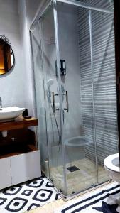 une douche en verre dans une salle de bain avec un lavabo dans l'établissement Superbe Appartement avec piscine et jacuzzi privé, à Casablanca