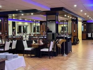 a restaurant with white chairs and tables and a bar at Bootshaus Hamm in Hamm