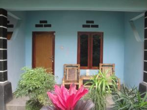a house with two chairs and a table and flowers at Sawe Homestay in Kuta Lombok