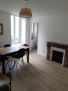 comedor con mesa y chimenea en Appart neuf, en Le Mans