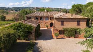 a large brick house with a driveway in front of it at Fattoria Belvedere alle Vigne VacaVilla Exclusive in Sinalunga