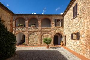 an external view of a brick building with potted plants at Fattoria Belvedere alle Vigne VacaVilla Exclusive in Sinalunga