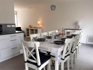 ein Esszimmer mit einem weißen Tisch und weißen Stühlen in der Unterkunft Maison familiale, proche des plages et des commerces in Piriac-sur-Mer