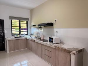 eine Küche mit einer Spüle und einer Mikrowelle auf der Theke in der Unterkunft Kajang KL 10Pax Landed Home Karaoke Netflix Long Stay in Semenyih + 34 Fotos