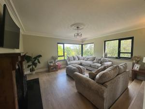 a large living room with a couch and a tv at Riversdale Road Tyrone Omagh Fermanagh 