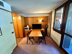 Habitación con mesa con sillas y ordenador. en Bilocale Des Alpes 204 - Serafini, en Madonna di Campiglio