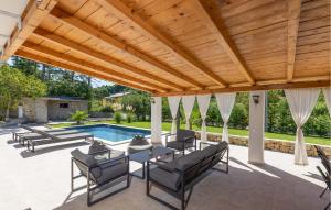 a patio with a wooden pergola and a swimming pool at 4 Bedroom Awesome Home In Mundanije in Mundanije