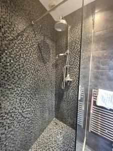 une douche avec une porte vitrée dans une salle de bain dans l'établissement citadelle - vue mer, à Bastia