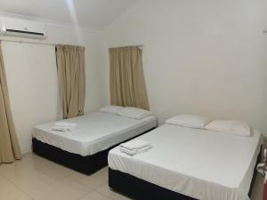 two beds in a small room with a window at Large 4 Bedroom 7 Bed Villa in Sonaisali Rd, Nadi in Nadi