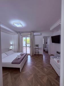 a white bedroom with a bed and a bathroom at Maison24 in Martinsicuro