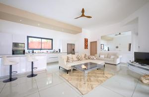 a living room with a couch and a table at Villa Coco Chic - Piscine privée - Paradis Tropical in Pointe aux Piments