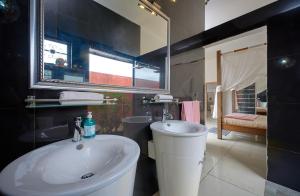 a bathroom with a white sink and a mirror at Villa Coco Chic - Piscine privée - Paradis Tropical in Pointe aux Piments +7 photos