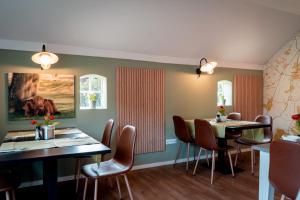 a dining room with two tables and chairs at Hotel B&B Hoeve de Vredenhof in Zuidlaren