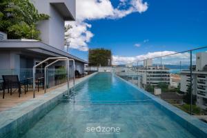a swimming pool on the roof of a building at Apt w/ balcony and grill 220m from the Sea ALB0201 in Florianópolis