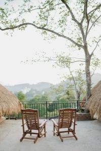 dos sillas de madera sentadas una al lado de la otra en un patio en Cliff Edge Villa, en Ella