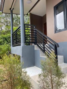 a house with stairs and a railing on it at Baan klang suan at kantiang bay in Ko Lanta