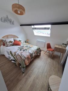 een slaapkamer met een bed, een tafel en een stoel bij A 2 pas de la plage in Le Portel
