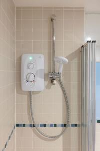 a shower with a shower head in a bathroom at Sunny 1 bedroom apartment, Ocean house, East wittering in East Wittering